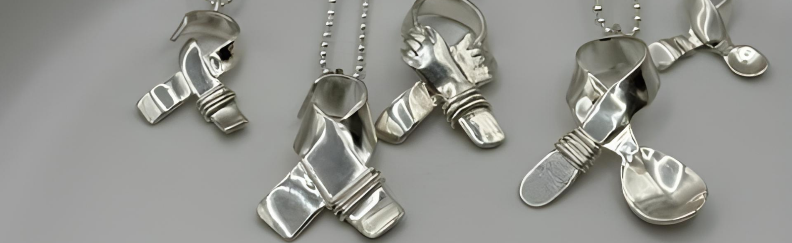 Silver ribbon pendants on a gray background